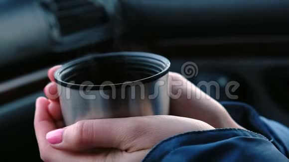 冬天一个女人手里拿着一杯热水瓶的热茶视频的预览图