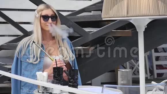 女人在露天吸烟女人在公园拉烟美丽的女孩在户外可爱的女人进入黑尔味道视频的预览图