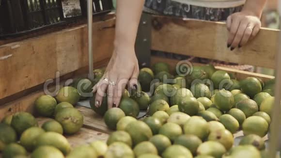 年轻漂亮的女人在超市为家人买新鲜健康的柠檬手臂选择美味的柑橘视频的预览图
