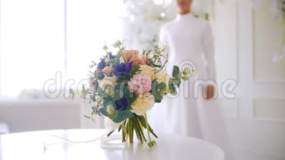 穿白色婚纱的新娘来到鲜花面前视频的预览图
