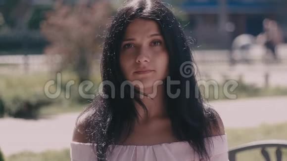 城市街道上模糊的背景上一幅美丽的年轻女子黑发的肖像关门视频的预览图