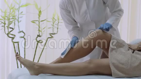 水疗中心的美容师为女性准备脱毛的腿4k视频的预览图