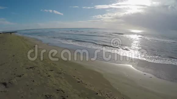 无人驾驶飞机飞过沙滩海浪冲上岸阳光明媚的天气塞浦路斯视频的预览图