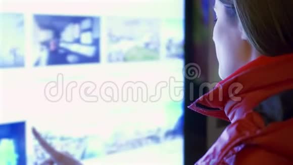 穿红色外套的年轻女人在户外使用触摸屏女性通过触摸屏幕做手势视频的预览图