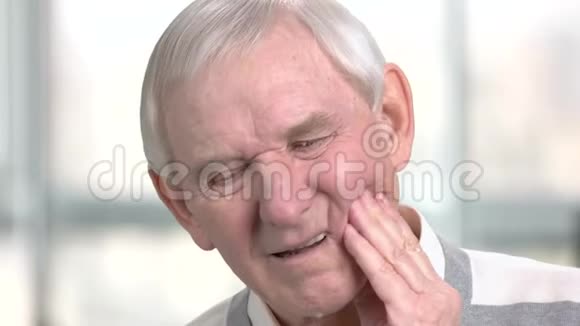 悲伤的老人摸着他的脸颊视频的预览图