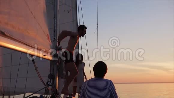 傍晚时分夕阳西下一个年轻人从一艘游艇跳进水里视频的预览图