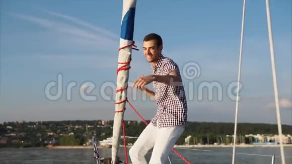 白天一个年轻而有魅力的男人在游艇上跳舞和胡闹视频的预览图