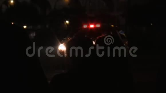 人们观察犯罪现场和警车闪烁的灯光视频的预览图