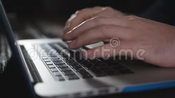 男人在办公室里用笔记本电脑键盘打字合上手提电脑键盘上的手写字视频的预览图