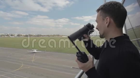 机场工作人员在控制塔内使用望远镜和便携式无线电视频的预览图