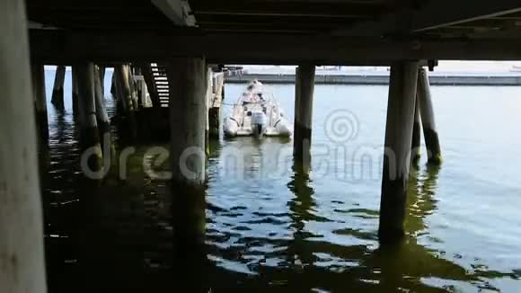 摩托艇停泊在古老的木墩上人们在钓鱼后离开船视频的预览图