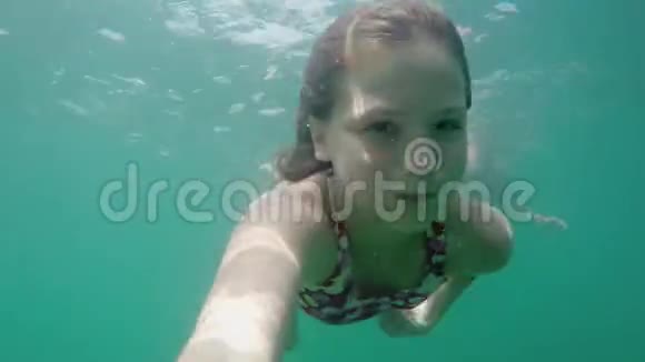 年轻的金发女郎穿着泳装在水下镜头下游泳水下镜头视频的预览图