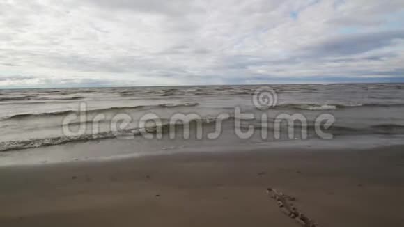 夏日的天空和大海在下面波浪在岸上飘落视频的预览图