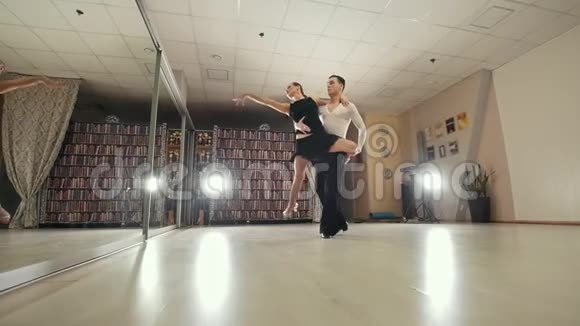 年轻迷人的男人和女人穿着服装在工作室里跳舞和练习拉丁美洲舞蹈慢动作在视频的预览图
