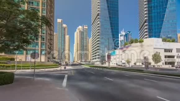 DubaiMarina的摩天大楼随着时间的推移在混凝土公路桥附近的街道上车辆通过运河视频的预览图
