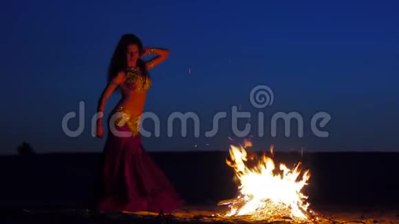 卷曲的黑发在火边跳舞背景是日落视频的预览图