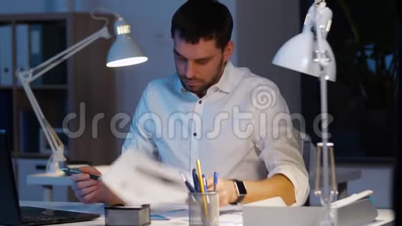 有文件和笔记本电脑的商人晚上工作视频的预览图