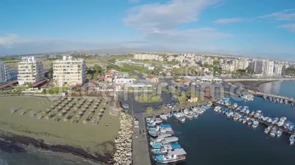 空中无人机在塞浦路斯拉纳卡镇的码头和菲尼库德斯海滩上空射击视频的预览图