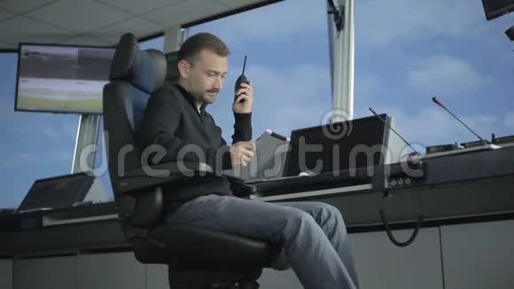 调度员在机场控制室使用平板电脑和便携式收音机视频的预览图
