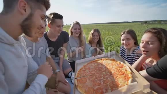 傍晚日落时分孩子们的朋友在户外吃披萨视频的预览图