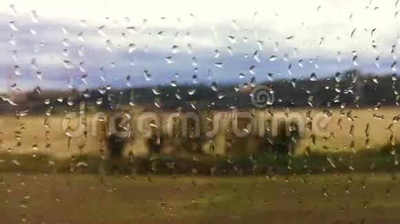 在雨天透过火车车窗观看乡村景色视频的预览图