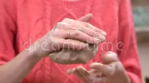 女陶工用手揉捏一块粘土然后再用它做一件工艺品视频的预览图