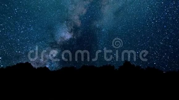 星星之夜的一段时间前景中有一棵树的影子有一个星迹效应银河时间流逝视频的预览图