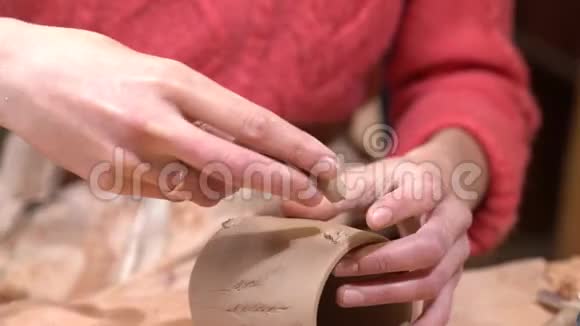 女陶工将手柄贴在生泥杯上视频的预览图