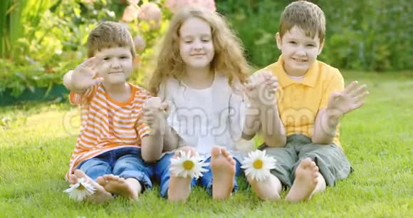 快乐的朋友孩子们在绿草地上开着雏菊视频的预览图