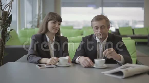两个商人在机场咖啡厅喝咖啡等待登机视频的预览图