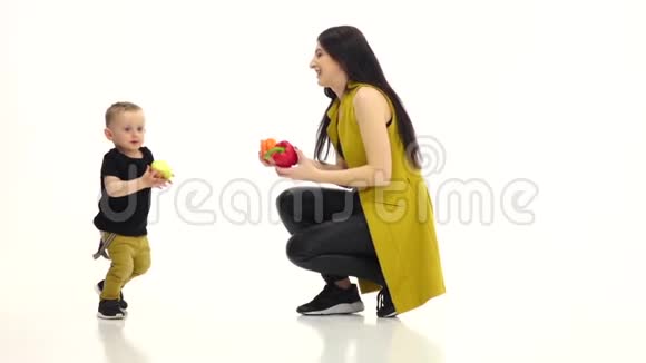 妈妈拿着两个辣椒宝宝有一个苹果他跑了白色背景慢动作视频的预览图