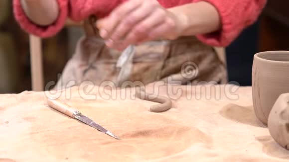 一个女孩陶工的特写用刀把装饰放在生泥部分视频的预览图