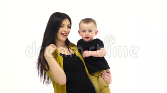 女孩把她的孩子抱在怀里白色背景慢动作视频的预览图