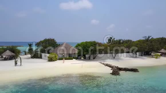 带白色沙滩棕榈树和棕榈树的热带岛屿度假酒店的女性前往温泉平房的鸟瞰图视频的预览图