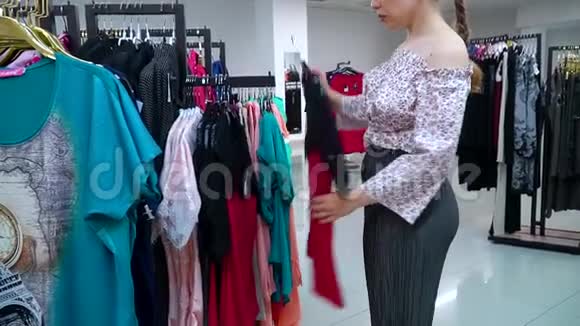 购物女孩漂亮的女孩在商店里选了一件衣服视频的预览图