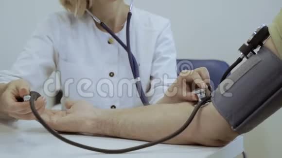 医生用血压计和听诊器检查老年人动脉脉搏视频的预览图