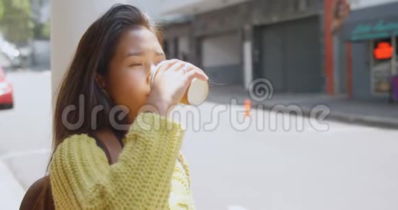 在街上喝咖啡的少女视频的预览图