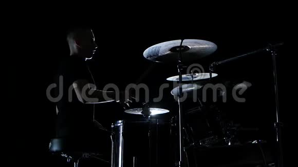 在一个专业的鼓手的完美表现中有很好的音乐侧视黑色背景慢动作视频的预览图