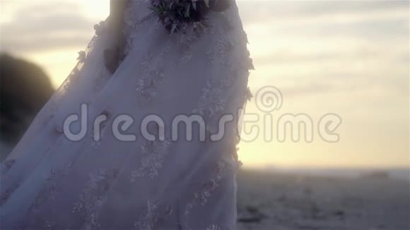 日落时穿着鲜花的婚纱慢动作视频的预览图