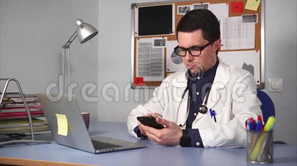 一位年轻的医生在私人诊所用手机检查X光照片视频的预览图