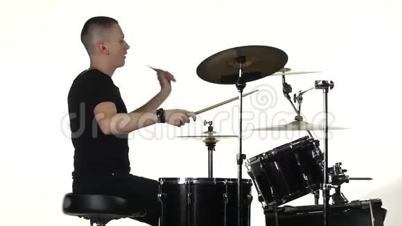 职业音乐家用棍子在鼓上演奏音乐白色背景侧视慢动作视频的预览图