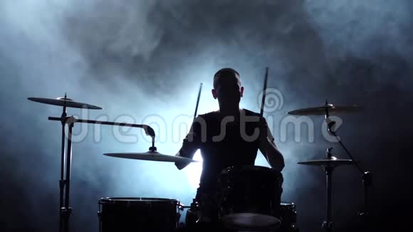 他在鼓上演奏音乐黑色烟熏背景剪影侧视慢动作视频的预览图