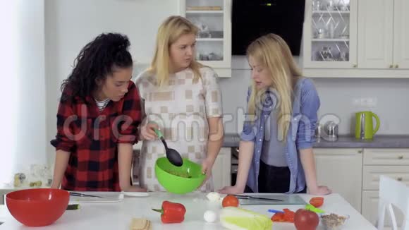 三个年轻女朋友在厨房准备新鲜沙拉视频的预览图