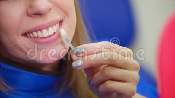 近距离拍摄一个女人嘴她检查她的牙齿是如何漂白的视频的预览图