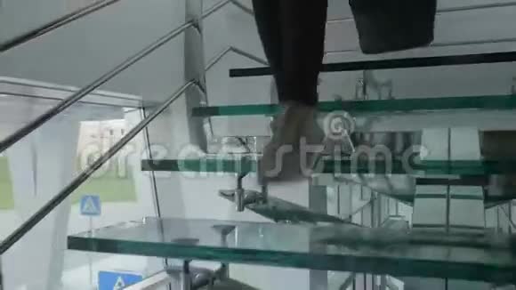 带包的女人走下玻璃楼梯视频的预览图