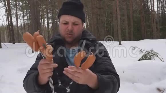 木棍上的两根香肠是在斯洛莫的篝火上煮熟的视频的预览图