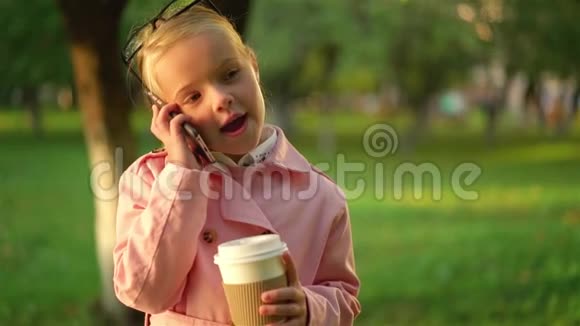 可爱的粉红色小女孩在电话里拿着咖啡视频的预览图