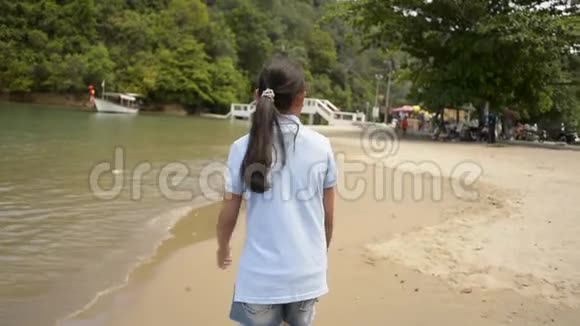 可爱的女孩在夏天在海滩上散步视频的预览图