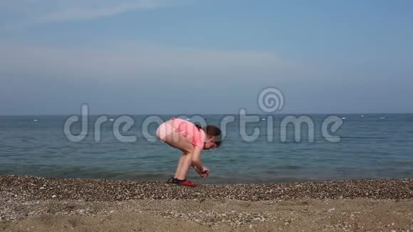 美丽的女孩把石头扔进海里视频的预览图