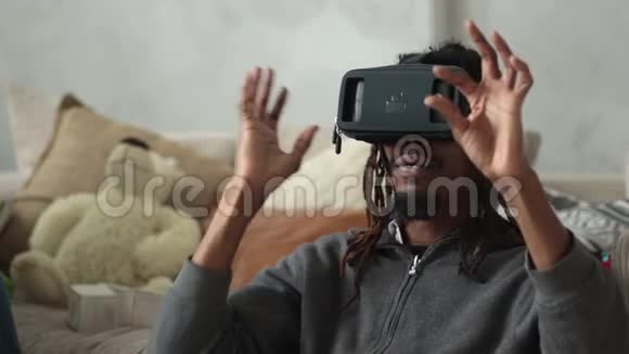 兴奋的男人在家里用虚拟现实护目镜视频的预览图